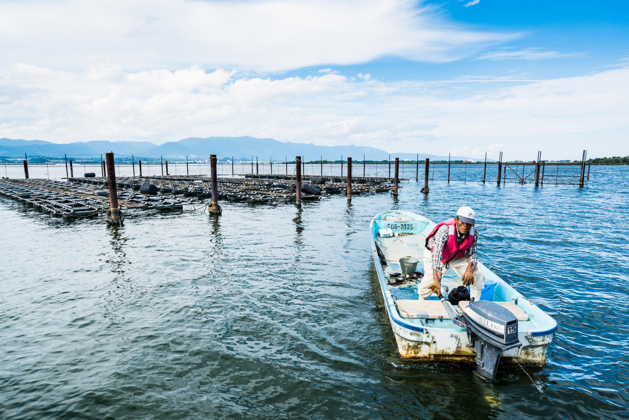 Pearl farmer Sueharu Hane checks cages on Lake Biwa in Shiga Prefecture. | PHILIPPE VOISIN