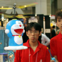 Taiyo Kogyo Co. employees demonstrate a radio-controlled Doraemon helicopter toy. | BLOOMBERG