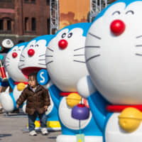 A child wanders among Doraemon figures in Yokohama. | GETTY IMAGES