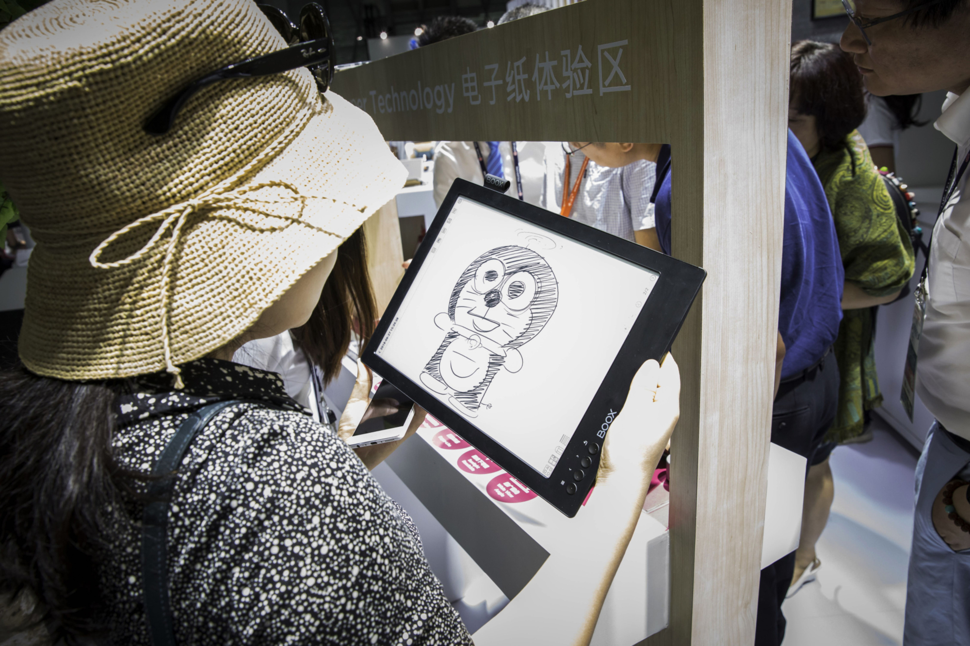 A woman looks at a sketch of the character Doraemon at an exhibition in Shanghai in 2018. | BLOOMBERG