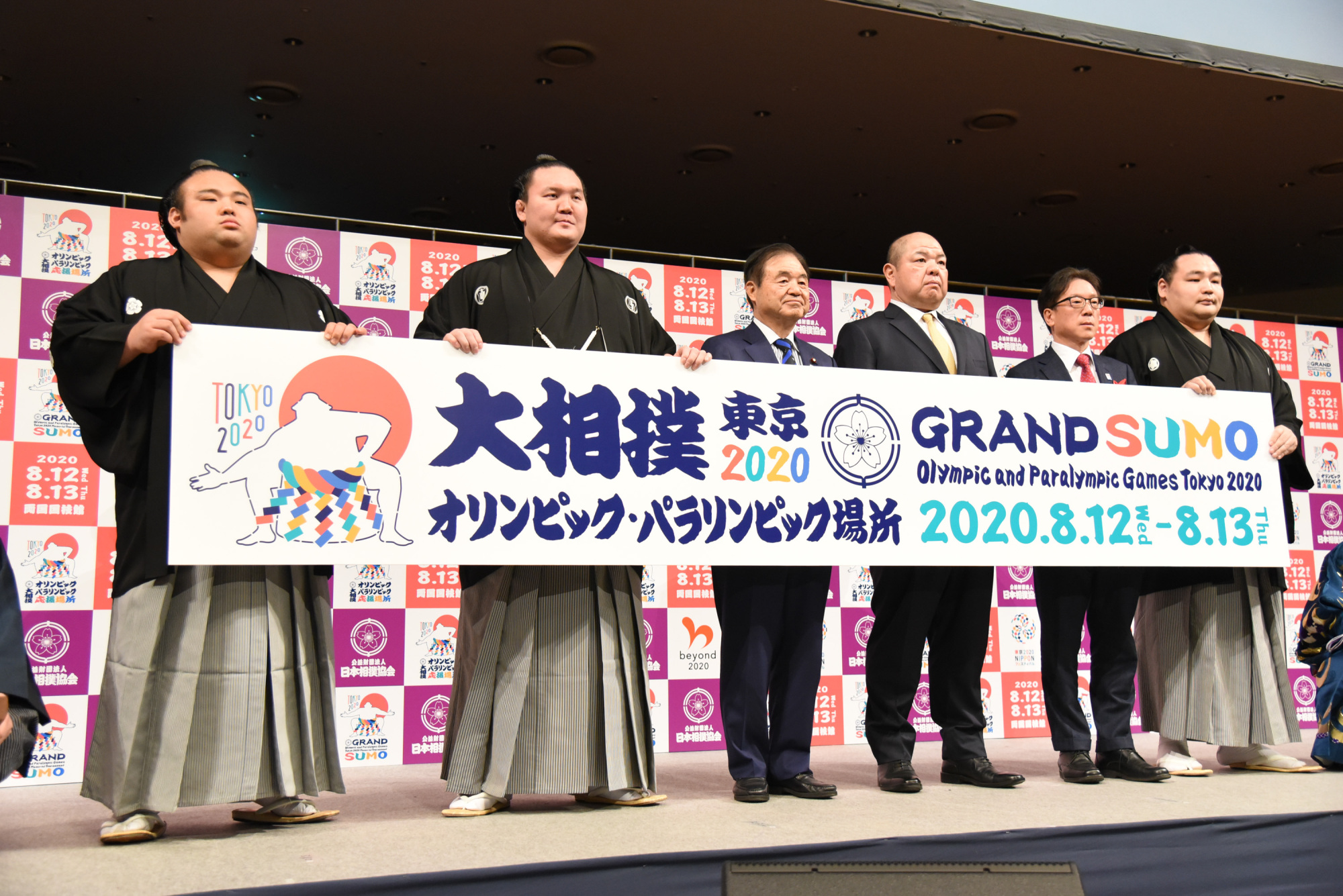 Ozeki Takakeisho (left) and yokozuna Hakuho (second from left) and Kakuryu (right) pose for photos during an event at Ryogoku Kokugikan on Tuesday. | DAN ORLOWITZ