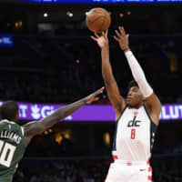 Wizards forward Rui Hachimura (right) shoots against Bucks forward Marvin Williams during overtime on Monday in Washington. | AP