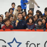 Evan Lysacek, the 2010 Olympic men\'s figure skating gold medalist, poses with participants during a clinic at Yokohama Bank Ice Arena on Thursday. | JASON COSKREY