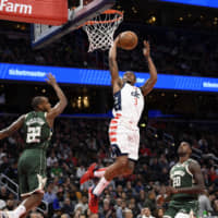 The Wizards\' Bradley Beal goes to the basket against the Bucks\' Khris Middleton and Marvin Williams in the second half on Monday in Washington. | AP