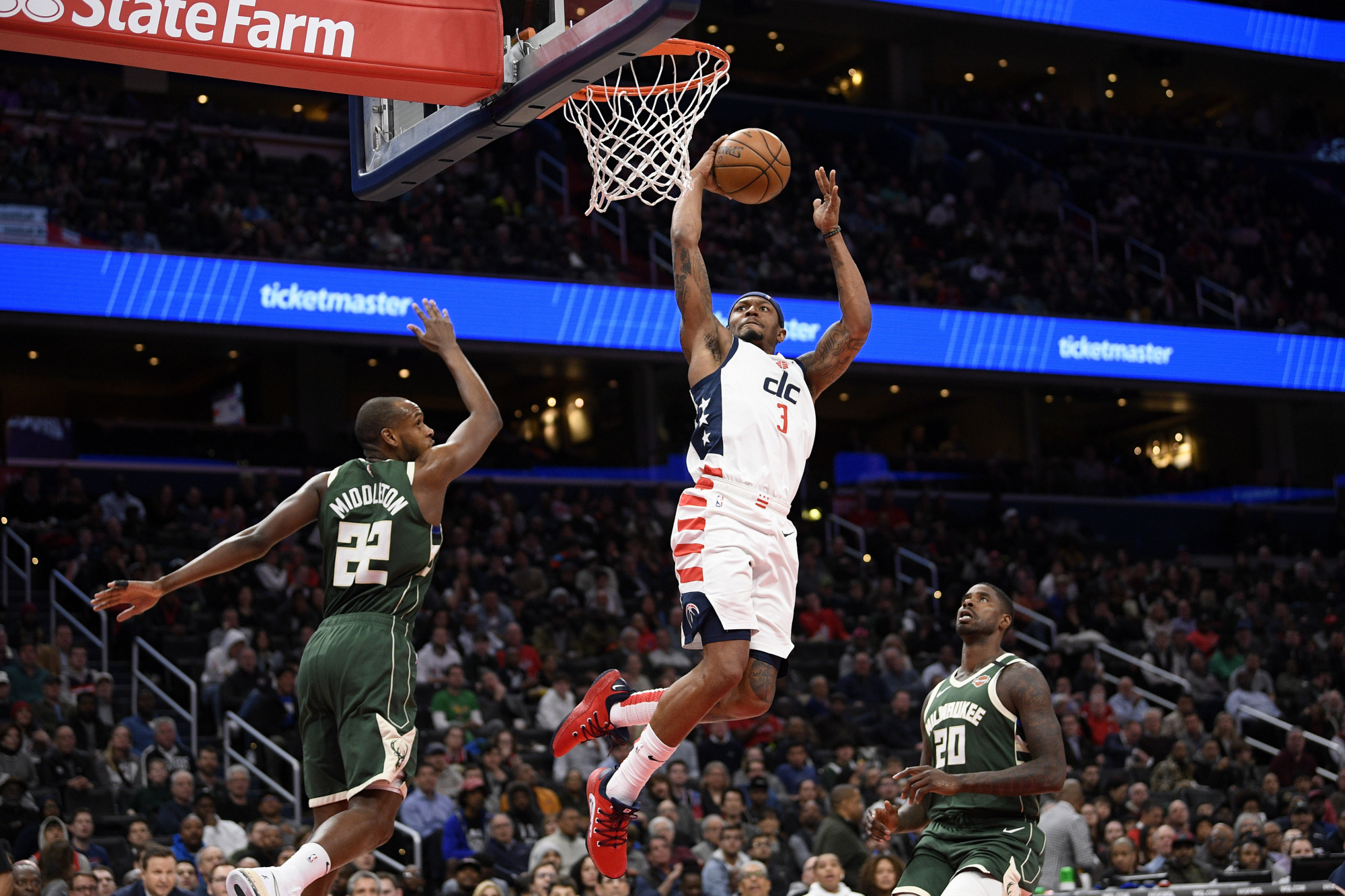 The Wizards' Bradley Beal goes to the basket against the Bucks' Khris Middleton and Marvin Williams in the second half on Monday in Washington. | AP