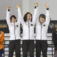 Japan team pursuit speedskaters (from left) Nana Takagi, Miho Takagi and Ayano Sato celebrate on the podium after breaking their own world record in the event on Friday at the ISU World Single Distances Speed Skating Championships in Salt Lake City. | KYODO