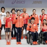 Japan Olympians and Paralympians pose in national team casual attire at a Friday news conference. | KYODO