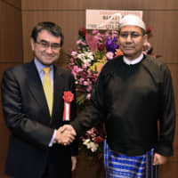 Ambassador of Myanmar Myint Thu (right) shakes hands with Defense Minister Taro Kono during a reception to celebrate the Republic of the Union of Myanmar\'s 72nd independence day anniversary at the embassy on Jan. 24. | YOSHIAKI MIURA