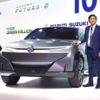 Kenichi Ayukawa, managing director and CEO of Maruti Suzuki India Ltd., a subsidiary of Suzuki Motor Corp., shows off a prototype electric vehicle at the Auto Expo in Greater Noida, near New Delhi, on Feb. 5. | KYODO