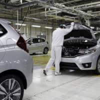 A Honda employee gives a Fit the final inspection at the automaker\'s Yorii plant in Saitama Prefecture. | BLOOMBERG