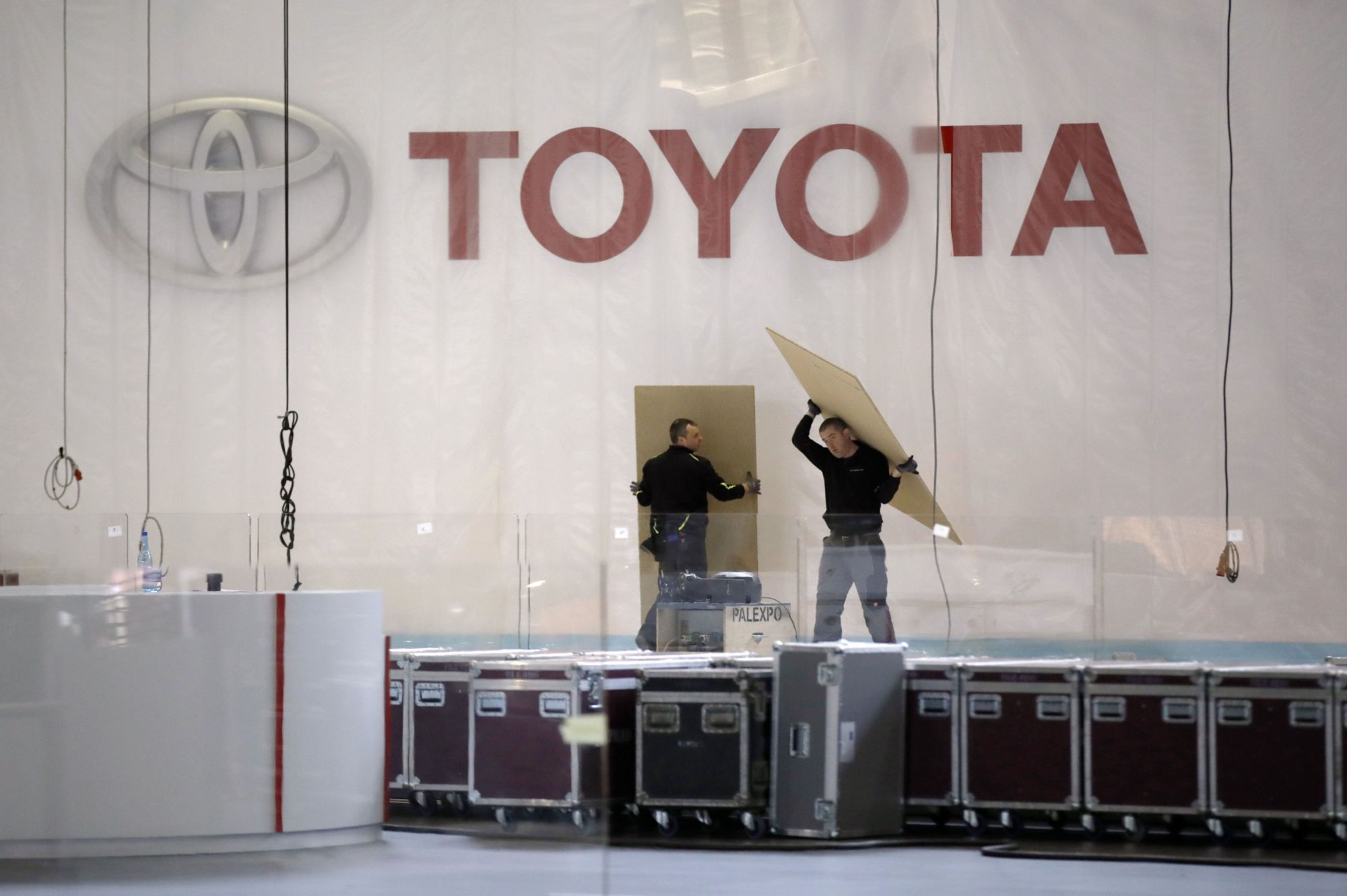 Workers dismantle a Toyota Motor Corp. pavilion at the canceled Geneva International Motor Show. Toyota said its idled manufacturing facilities in the U.S. will make face shields and masks. | BLOOMBERG