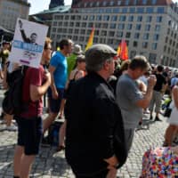 Demonstrators hold posters reading \"Never Again!\" and depicting Alternative for Germany (AfD) politician Bjoern Hoecke making a Nazi salute as they attend a protest rally titled \"Unteilbar\" (\"Indivisible\") against exclusion in Dresden, eastern Germany, on August 24, 2019. | AFP-JIJI