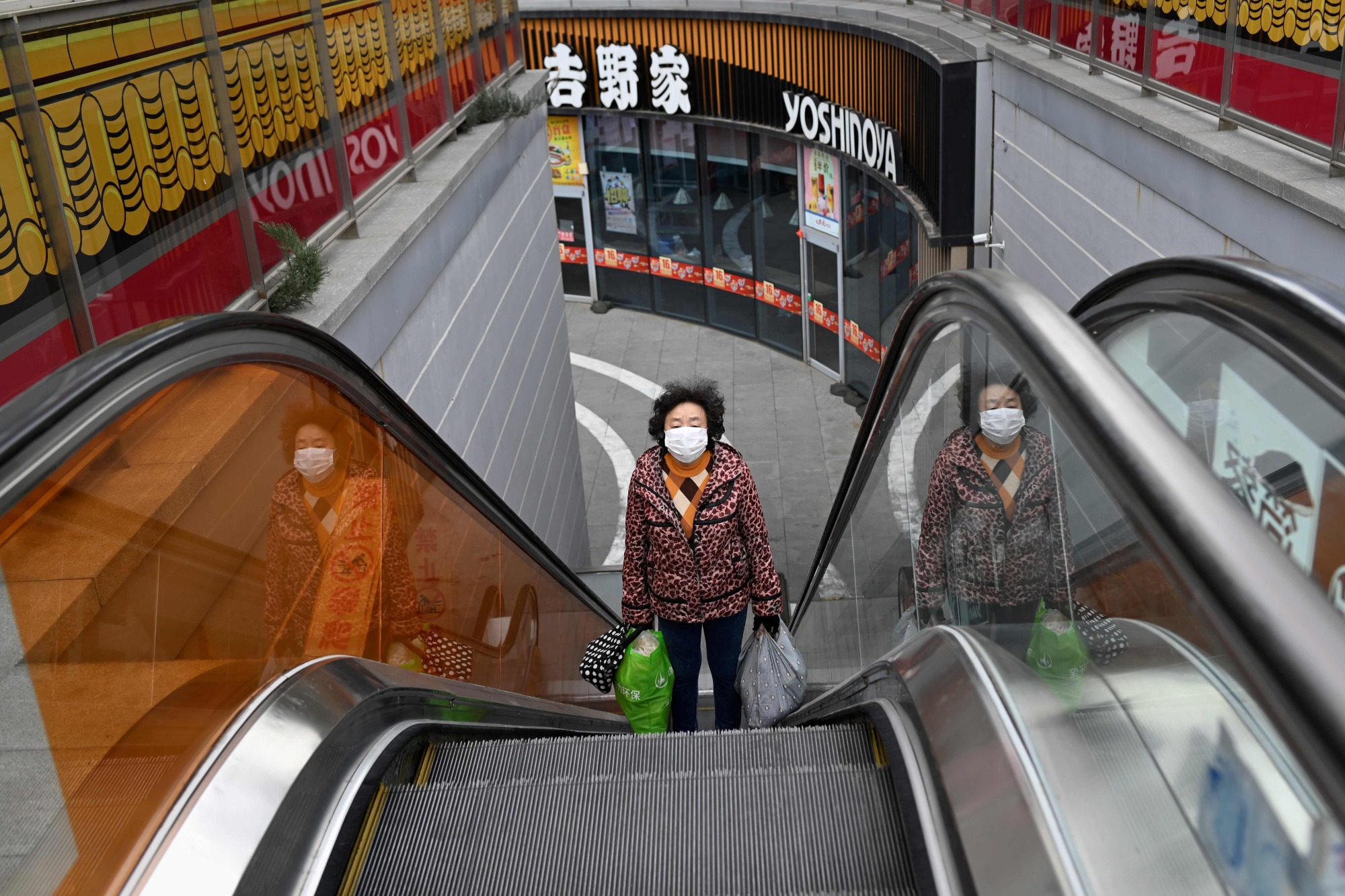 A woman leaves a supermarket at a nearly empty mall in Beijing on Thursday. | AFP-JIJI