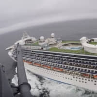 A helicopter carrying airmen with the 129th Rescue Wing flies over the Grand Princess cruise ship off the coast of California on Thursday. | CALIFORNIA NATIONAL GUARD / VIA AP