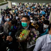 Chan Kin-man (center) shakes the hand of a supporter after his release from Pik Uk prison in Hong Kong on Saturday. | AFP-JIJI