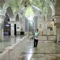 A man disinfects the shrine of the Shiite Saint Imam Abdulazim to help prevent the spread of the new coronavirus in Shahr-e-Ray, south of Tehran, Iran, on Saturday. | AP