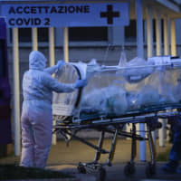 A patient in a biocontainment unit is carried on a stretcher at the Columbus Covid 2 Hospital in Rome on Monday. | AP