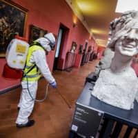 A worker sprays disinfectant as sanitization operations against the new coronavirus are carried out in the museum hosted by the Maschio Angioino medieval castle in Naples, Italy, on March 10. | AP