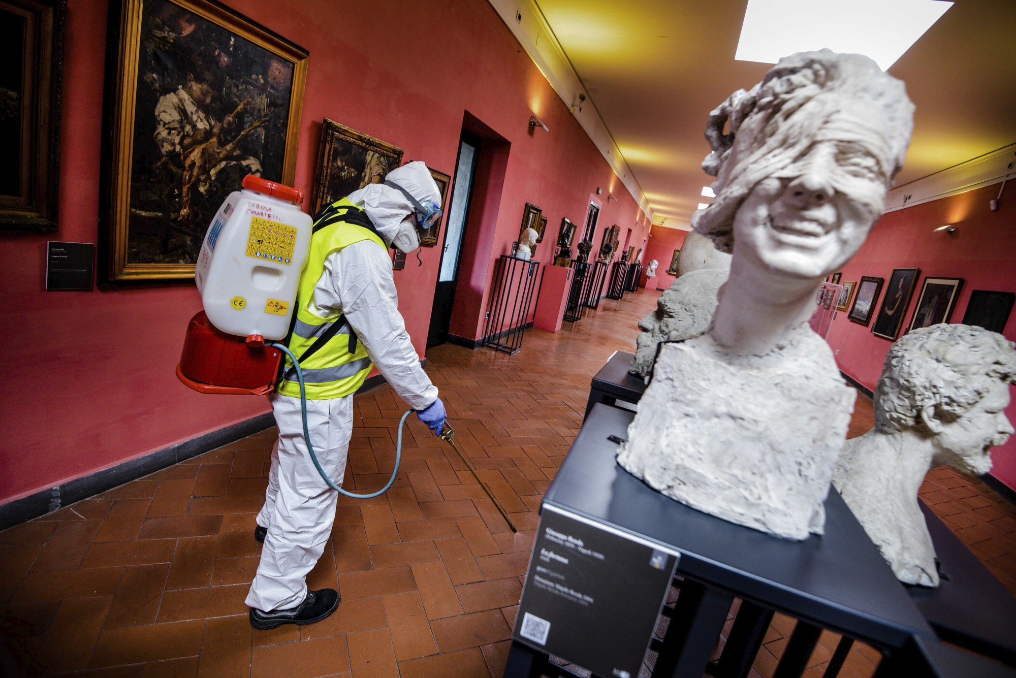 A worker sprays disinfectant as sanitization operations against the new coronavirus are carried out in the museum hosted by the Maschio Angioino medieval castle in Naples, Italy, on March 10. | AP