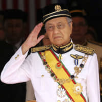 Mahathir Mohamad, then Malaysia\'s prime minister, salutes during the opening of the 14th parliament session in Kuala Lumpur in 2018. Mahathir abruptly resigned last Monday. | AP