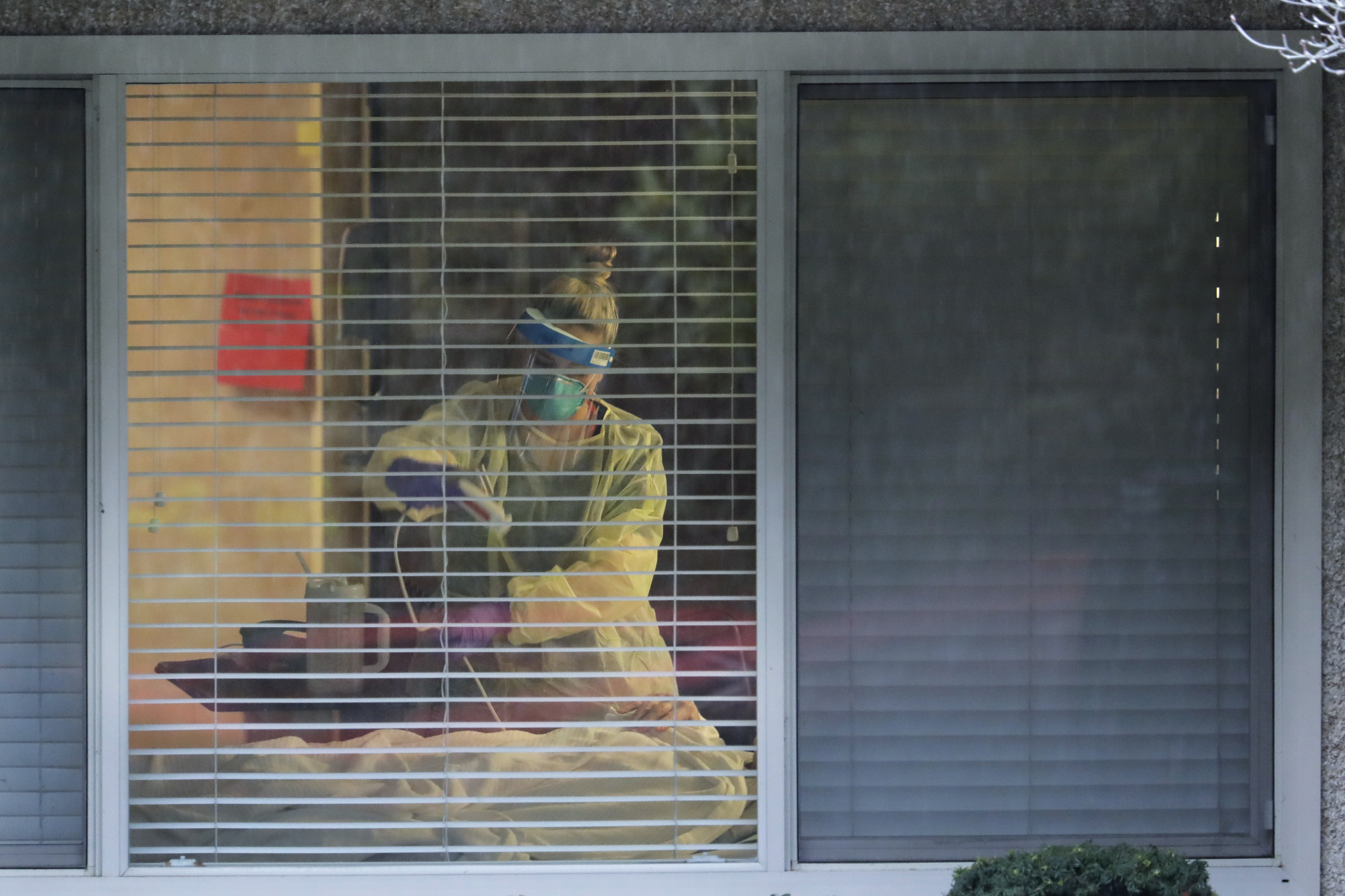 A nurse works in the room of a patient who tested positive for the COVID-19 coronavirus at the Life Care Center on March 13 in Kirkland, Washingon, near Seattle. | AP