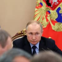 Russian President Vladimir Putin chairs a meeting at the Kremlin in Moscow on Tuesday. | VIA REUTERS
