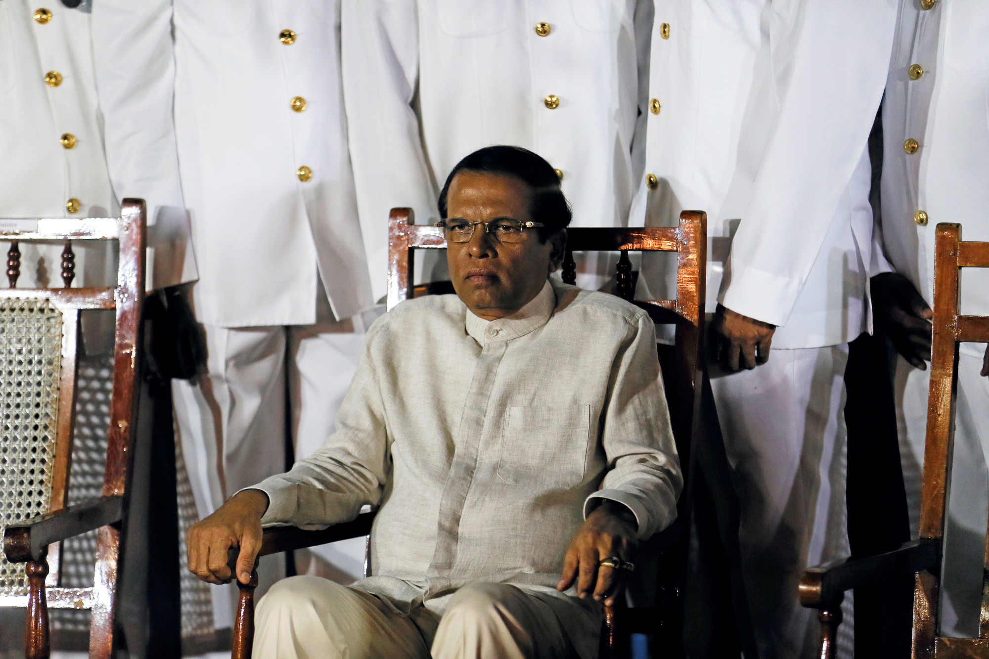 Then-Sri Lankan President Maithripala Sirisena, shown with navy officers during a ship commissioning ceremony last June, failed to fulfill his pledge to return all private land held by the military in the northern and eastern provinces by the end of 2018. | REUTERS