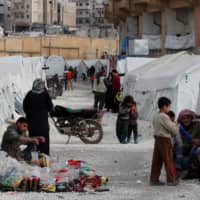 Internally displaced Syrians take shelter at an IDP camp in a sports stadium in Idlib, where tents are pitched under concrete terraces and near a parking area, on Feb. 27. | REUTERS