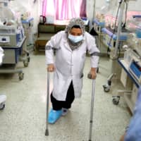 A nurse with a broken leg works in a room where premature babies are cared for in incubators at a maternity hospital in Idlib on Feb. 27. | REUTERS