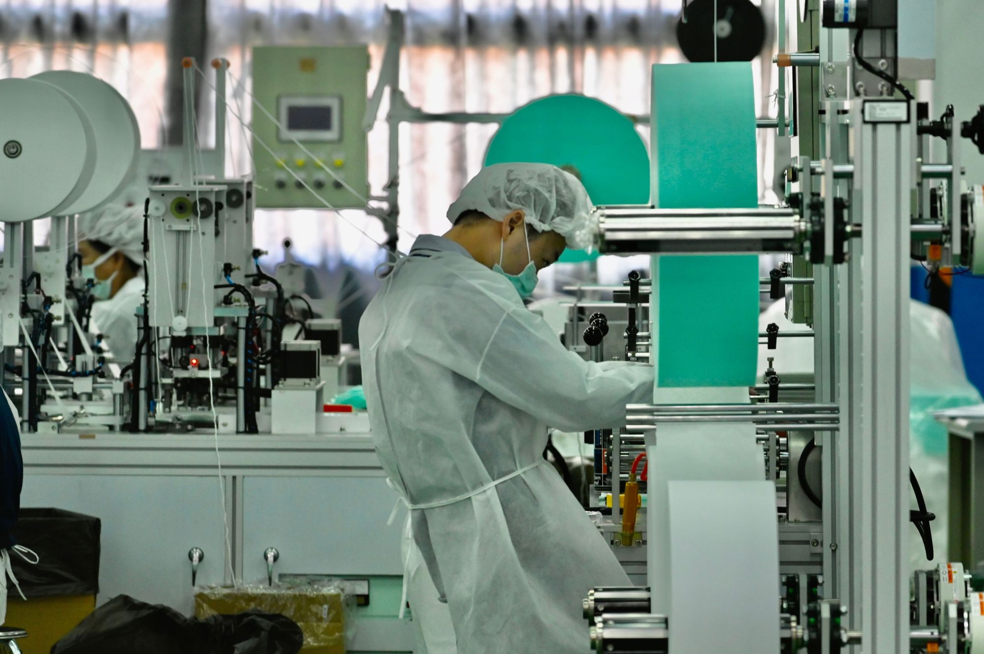 An employee with Taiwan's Universal Incorporation, one of the country's major mask makers, operates machines at a factory in Tainan on March 6. | AFP-JIJI