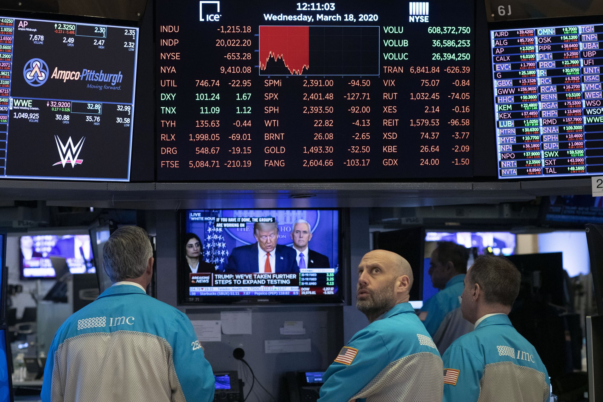 Traders at the New York Stock Exchange watch U.S. President Donald Trump's televised White House news conference on Wednesday. | AP