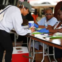 A voter signs her ballot before casting her vote at a polling center during the Democratic presidential primary election in Miami on Tuesday. | REUTERS