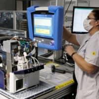 An employee of Hamilton Medical AG tests a ventilator at a plant in Domat/Ems, Switzerland on March 18. | REUTERS