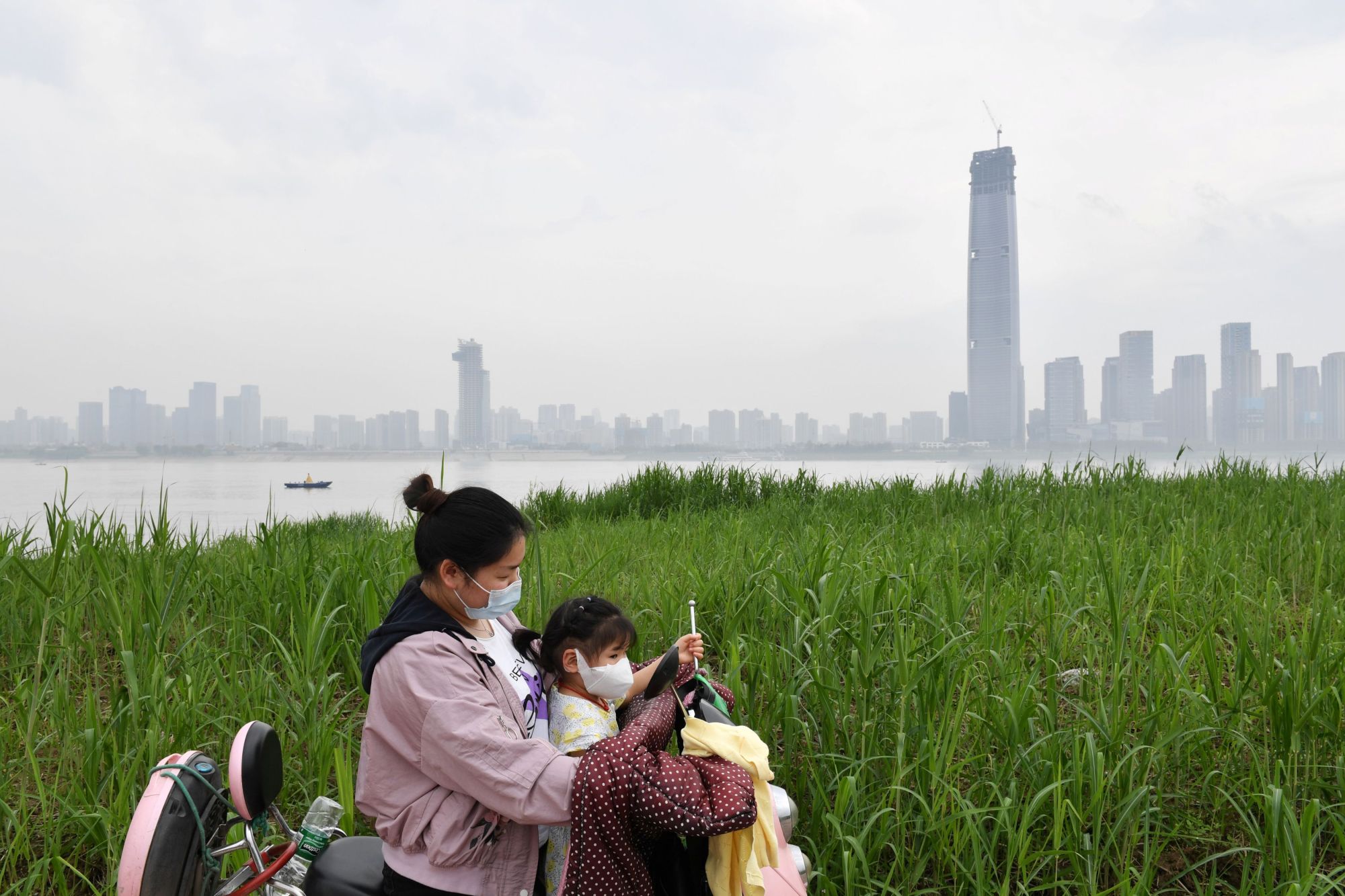 A mother and child at a park by the Yangtze River in Wuhan, China, on Thursday | REUTERS