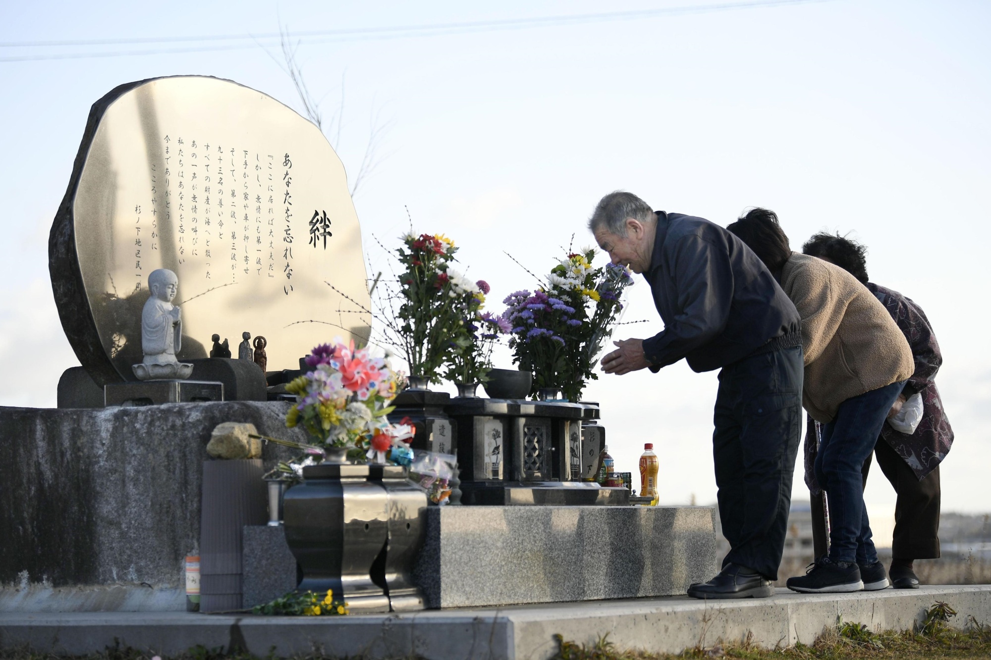 People offer prayers in front of a memorial in Kesennuma, Miyagi Prefecture, on Wednesday morning, the ninth anniversary of the earthquake and tsunami that struck on March 11, 2011. | KYODO