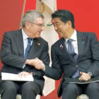 International Olympic Committee chief Thomas Bach and Prime Minister Shinzo Abe shake hands in Tokyo on July 24, 2019, during an event marking the start of the one-year countdown to the opening of the 2020 Tokyo Olympics. | KYODO