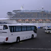 A coach travels toward the Diamond Princess cruise ship, docked in Yokohama on Feb. 16. | BLOOMBERG