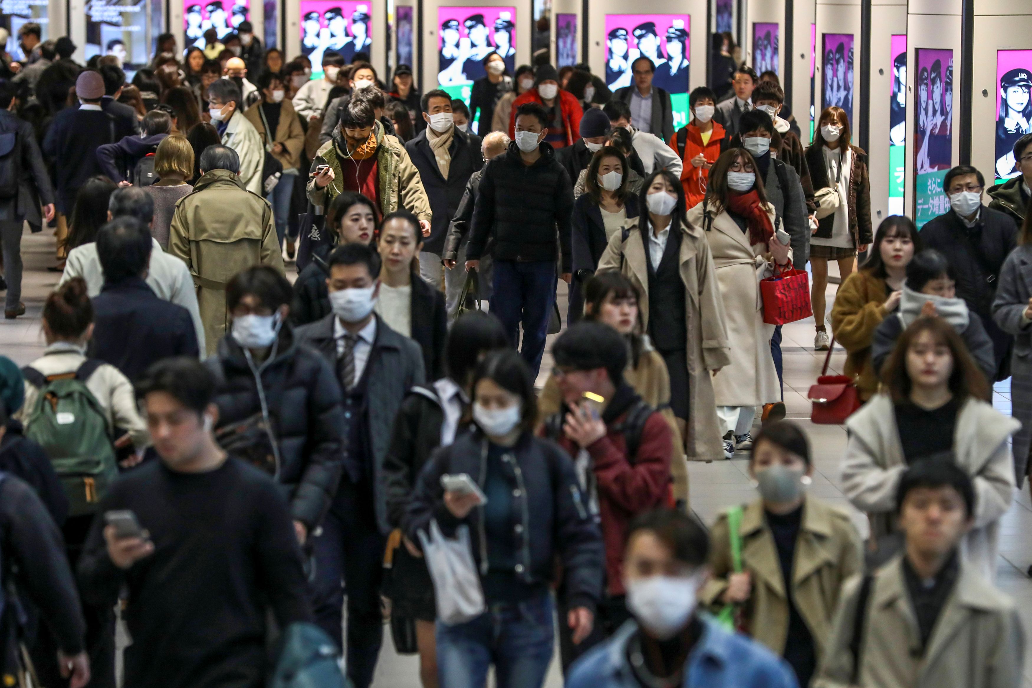 People wearing protective masks, following the COVID-19 outbreak, are seen at Shinjuku Station in Tokyo on Tuesday. | REUTERS