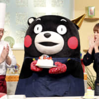 Kumamon receives a birthday cake in Kumamoto during a local TV program aired Thursday. | KYODO