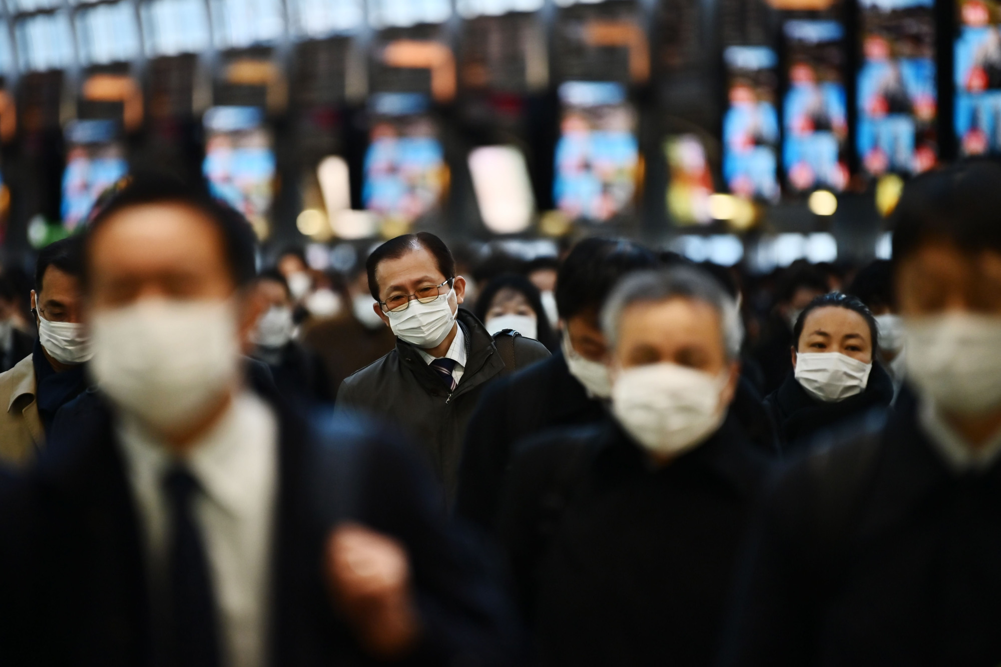 Mask-clad commuters make their way to work during morning rush hour at Shinagawa Station in Tokyo on Friday. | AFP-JIJI
