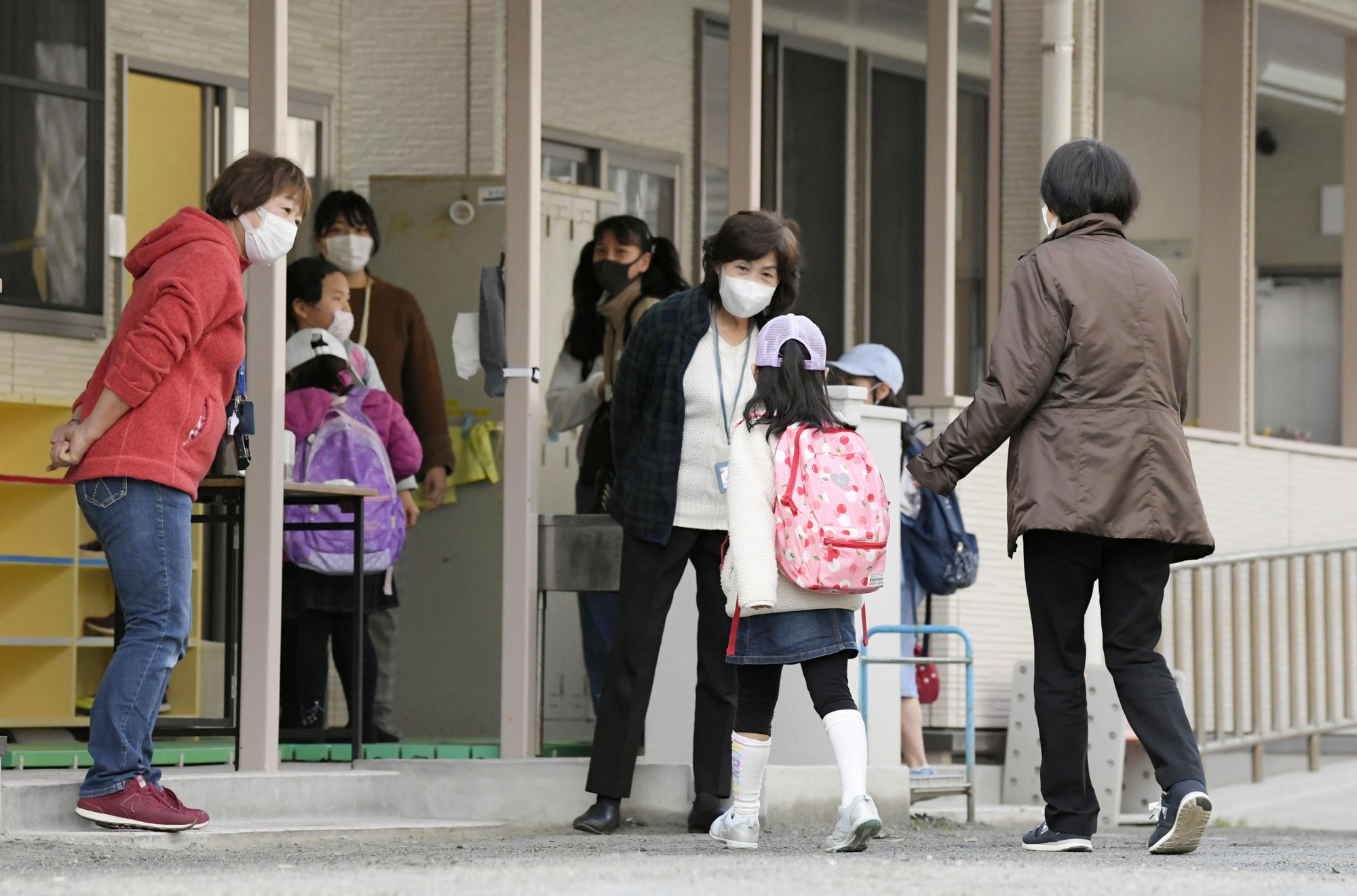 Children arrive at a school in Fukuoka on Monday morning. Classes are not being held, but the school opened for children whose parents are not home during the day. | KYODO