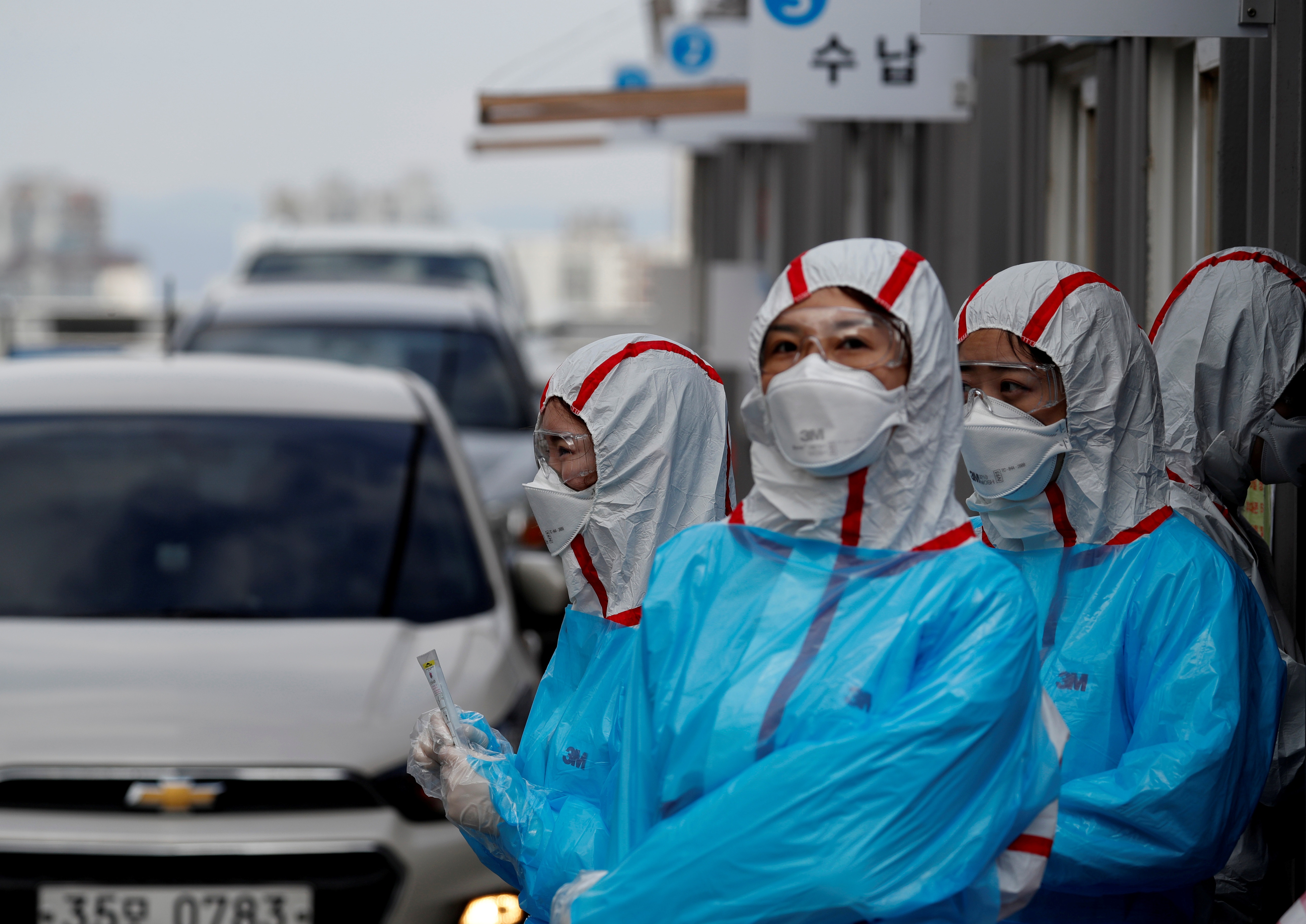 Medical staff work at a drive-thru testing center for the novel coronavirus at Yeungnam University Medical Center in Daegu, South Korea, on March 3. | REUTERS