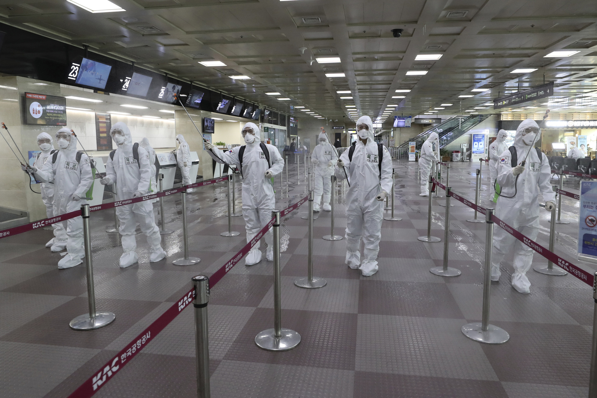 South Korean soldiers wearing protective suits spray disinfectant to prevent the spread of the new coronavirus at Daegu International Airport on Friday. Seoul expressed 'extreme regret' Friday over Japan's request that people arriving from South Korea and China undergo 14-day quarantines due to a surge in viral infections. | AP