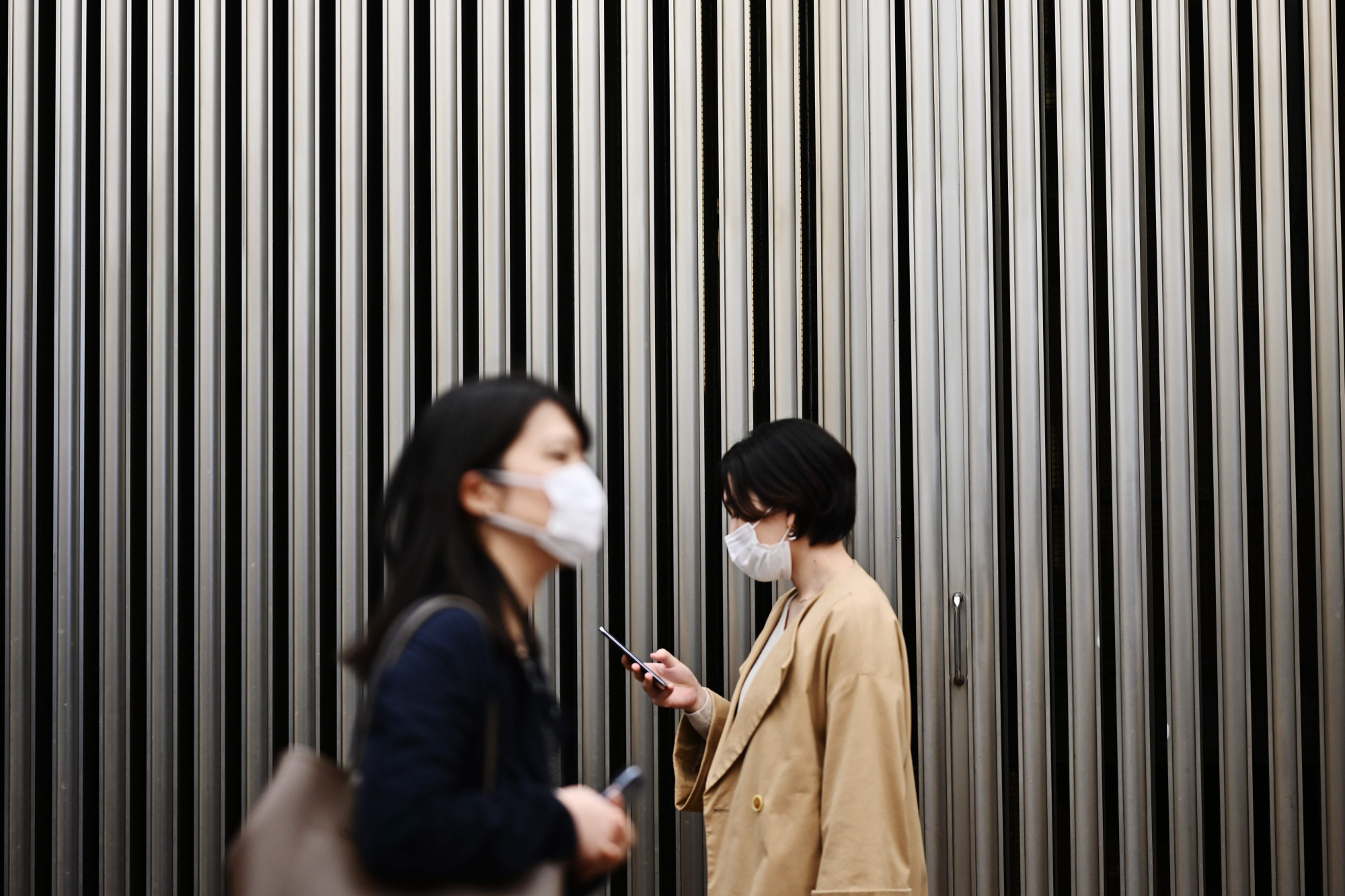 People wear face masks amid concerns over COVID-19 in Tokyo's Yurakucho district on Wednesday. Health experts have been puzzled as to why Japan is still seeing a relatively low number of infections from the deadly virus outbreak so far. | AFP-JIJI