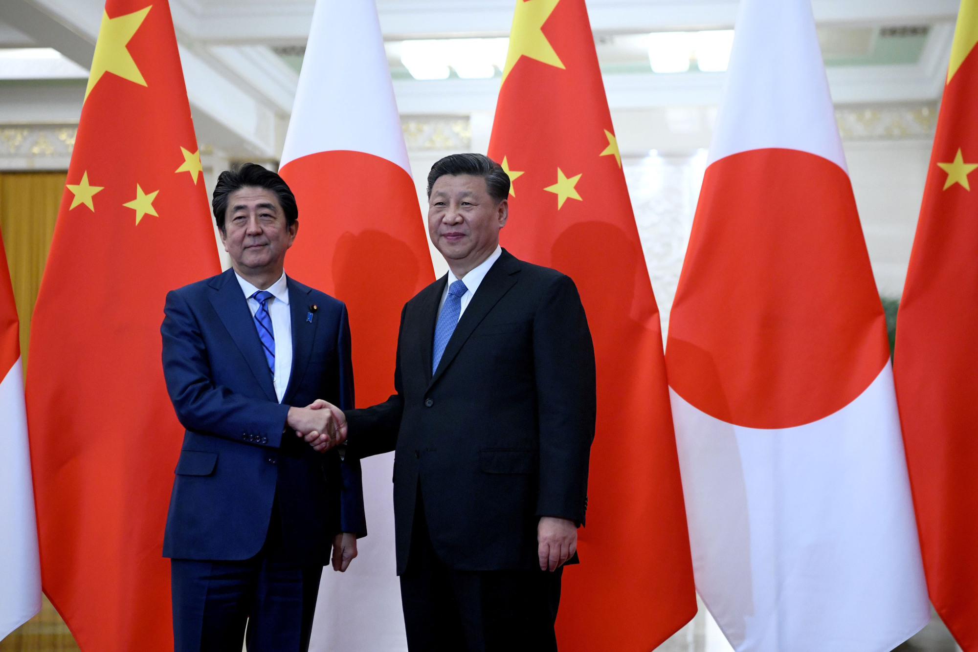Prime Minister Shinzo Abe shakes hands with China's President Xi Jinping at the Great Hall of the People in Beijing on Dec. 23. | REUTERS
