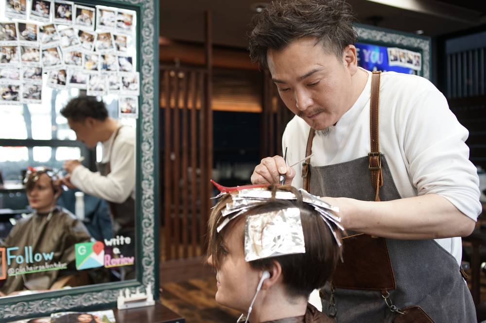 Koichi Nihei, a hairdresser at Pia Hair Salon Tokyo in Shibuya Ward, says he and his staff go without face masks, as the practice of wearing masks — less common overseas — could scare away its foreign patrons.  | RYUSEI TAKAHASHI