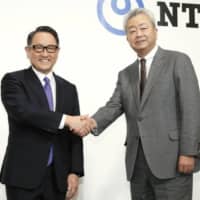Toyota Motor Corp. President Akio Toyoda and Nippon Telegraph and Telephone Corp. President Jun Sawada shake hands during a news conference in Tokyo on Tuesday. |  | KYODO