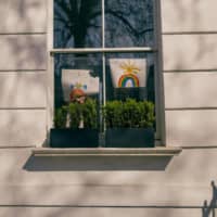 Over the rainbow: Hand-painted art is displayed in the window of a home in London during a city-wide lockdown caused by the rapid spread of COVID-19. Non-Japanese residents in Japan receiving word of the situation from family and friends overseas are likely to feel stress due to their inability to help out.  | BLOOMBERG
