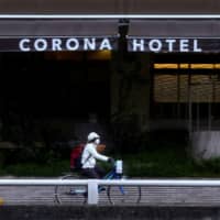 A man passes in front of the Corona Hotel in the city of Osaka on March 14. | REUTERS