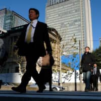 Pedestrians walk past the Bank of Japan (BOJ) headquarters in Tokyo, Japan, on Friday, Jan. 4, 2019. Japan’s benchmark bond yield fell to the lowest in more than two years on Friday as a stronger yen and a slowdown in global manufacturing spurred demand for the assets as a haven. | BLOOMBERG